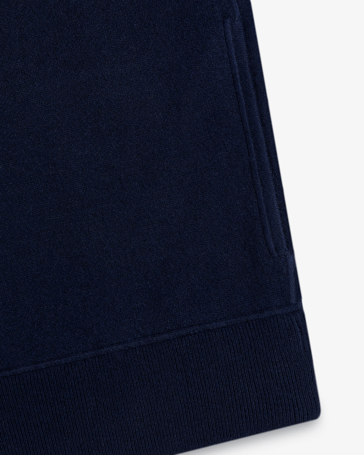 Close-up of the Quarter Zip Pavilion Cashmere Pullover’s navy sleeve with ribbed cuff and side pocket on white.