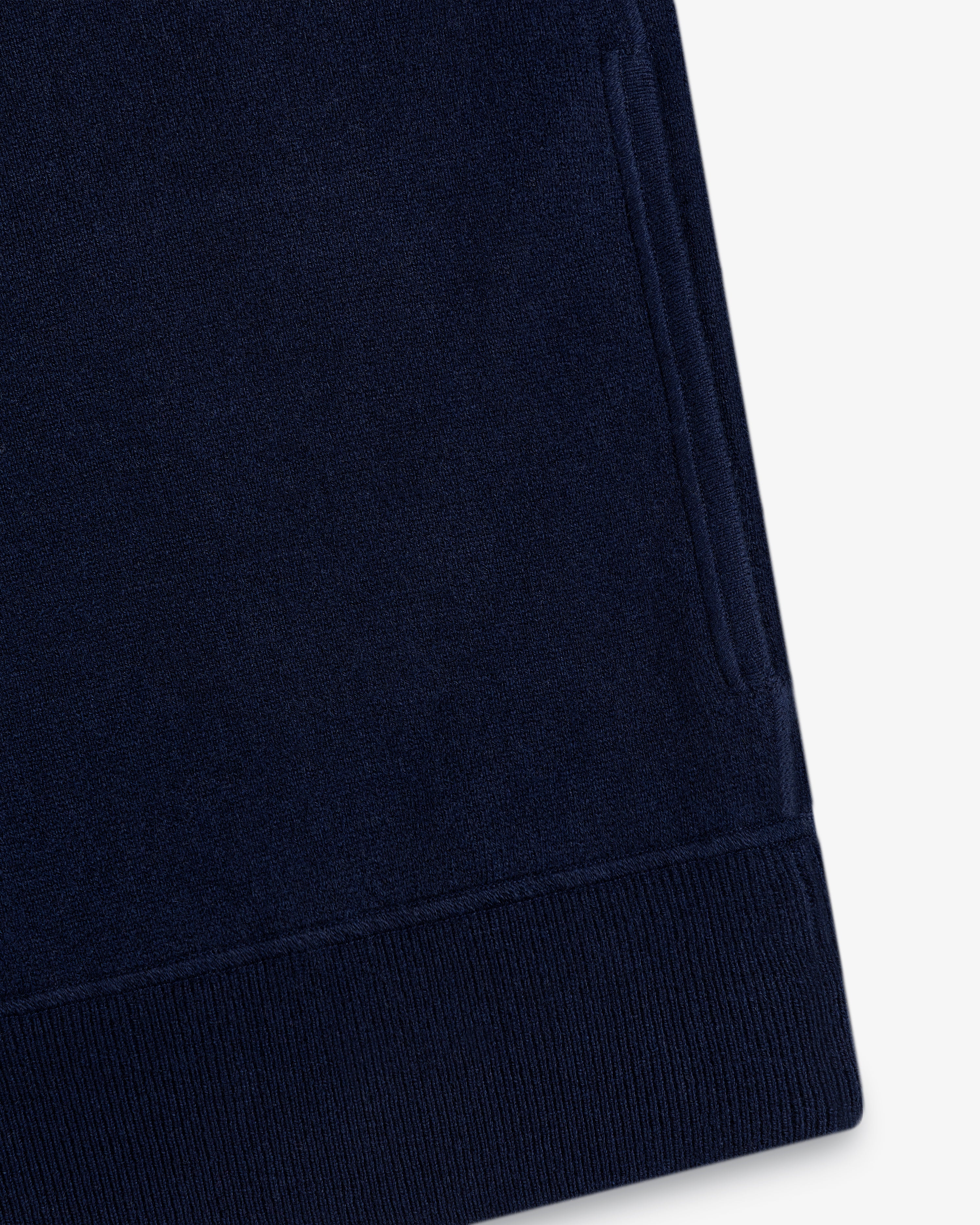 Close-up of the Quarter Zip Pavilion Cashmere Pullover’s navy sleeve with ribbed cuff and side pocket on white.