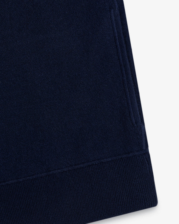 Close-up of the Quarter Zip Pavilion Cashmere Pullover’s navy sleeve with ribbed cuff and side pocket on white.