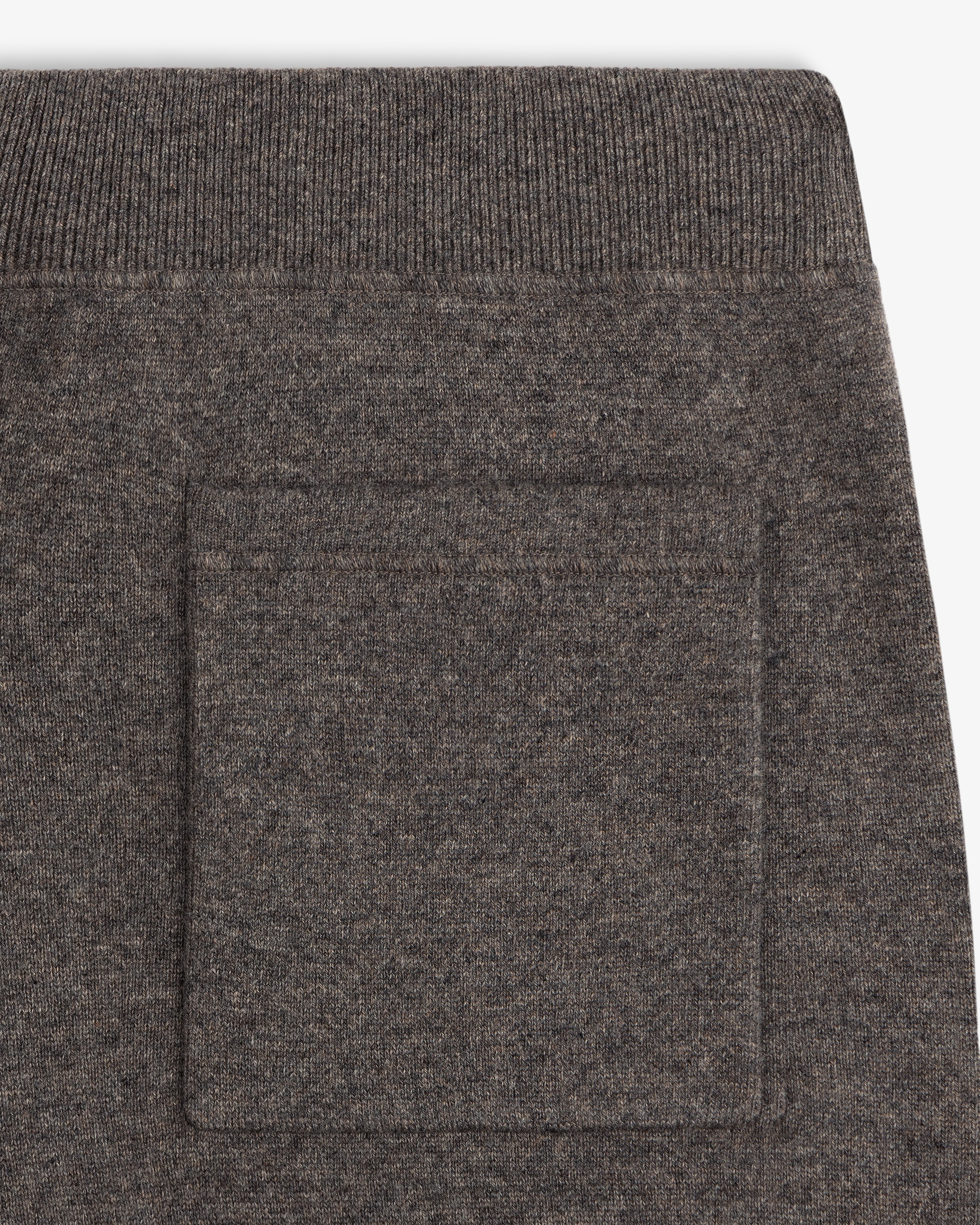 Close-up of a Pavilion Cashmere Sweatpant showing brown knit pocket detail and ribbed waistband above.