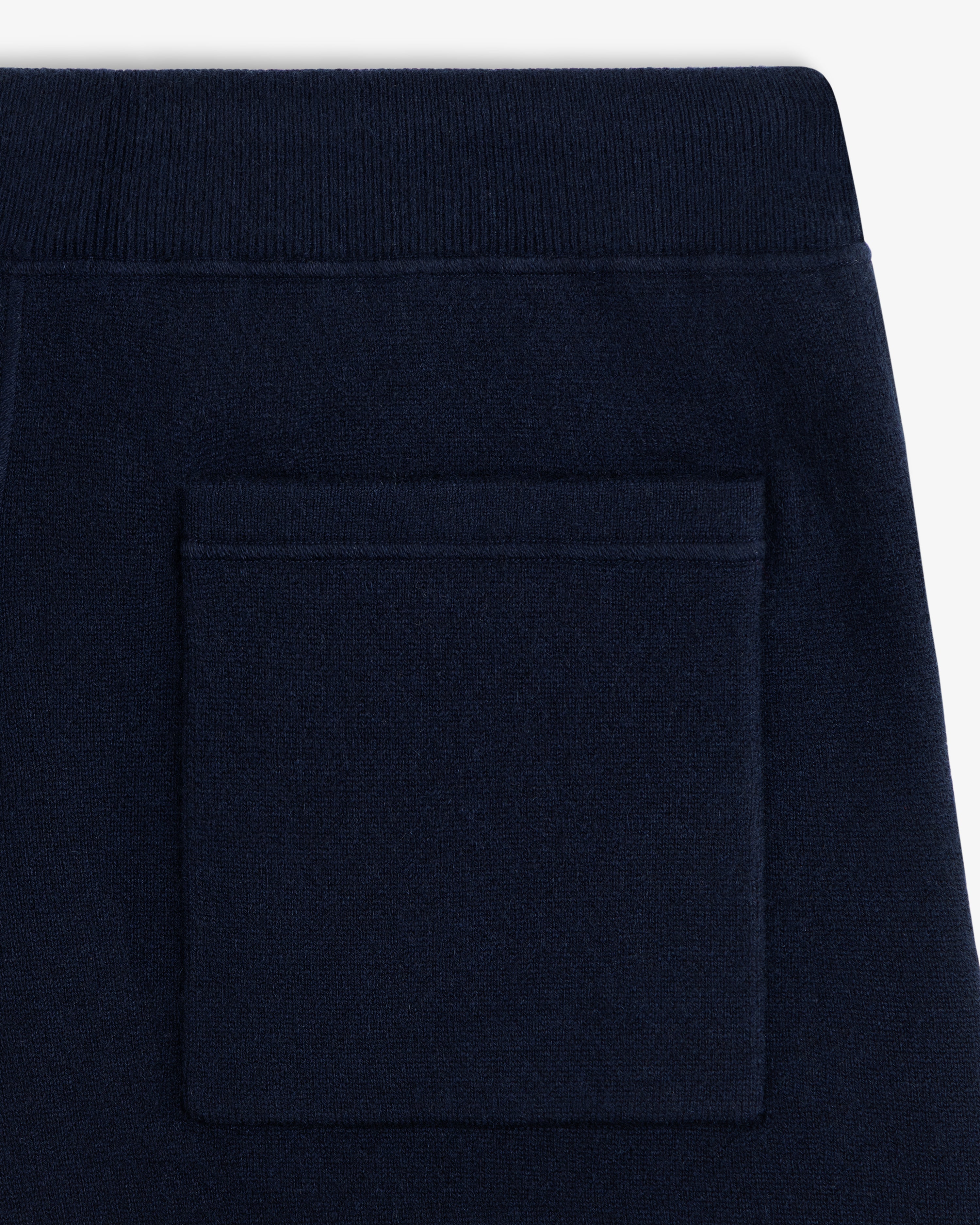 Close-up of Pavilion Cashmere Sweatpant back pocket with ribbed elastic waistband in dark navy blue.