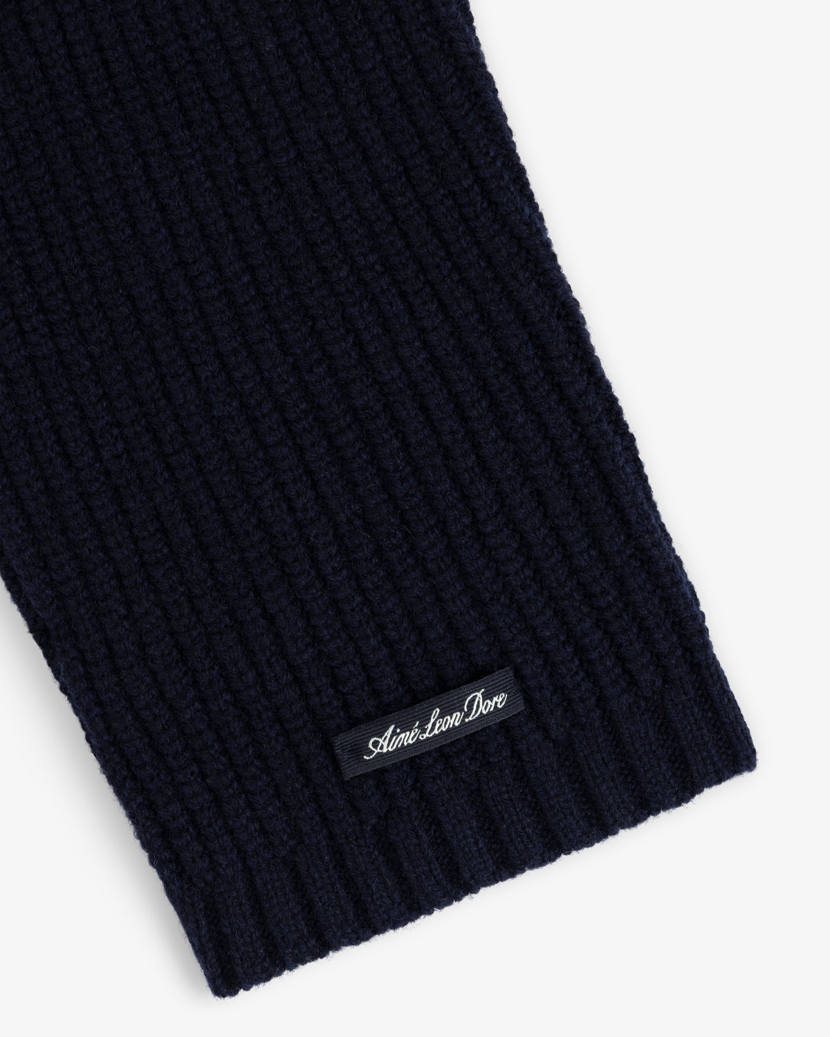 Close-up of a navy NY Highlanders Ribbed Wool Crewneck Sweater with Aimé Leon Dore label sewn near the edge.