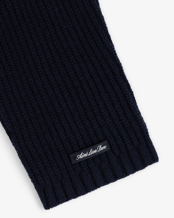 Close-up of a navy NY Highlanders Ribbed Wool Crewneck Sweater with Aimé Leon Dore label sewn near the edge.