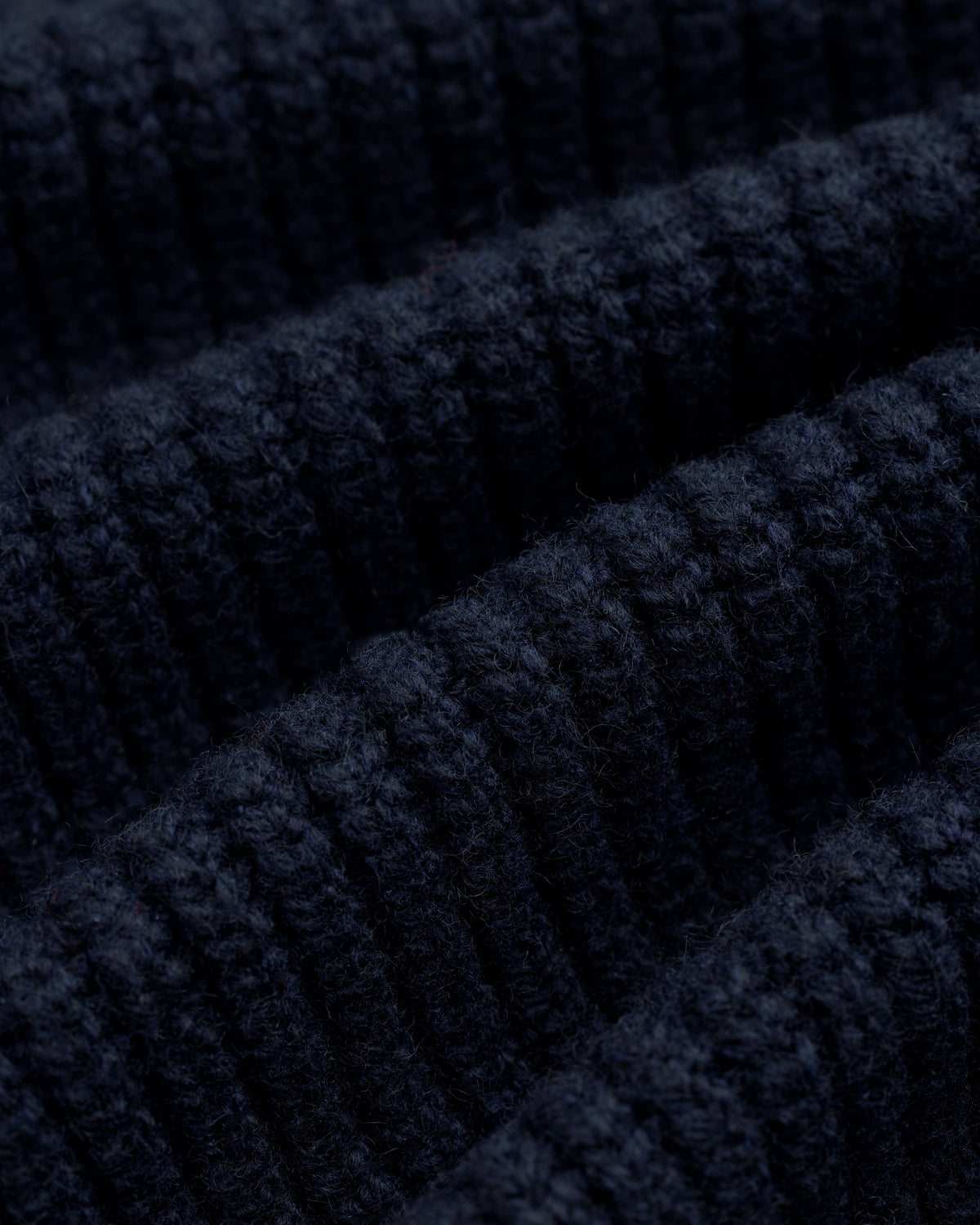 Close-up of NY Highlanders Ribbed Wool Crewneck Sweater, showing textured dark blue knit and soft wool fibers.