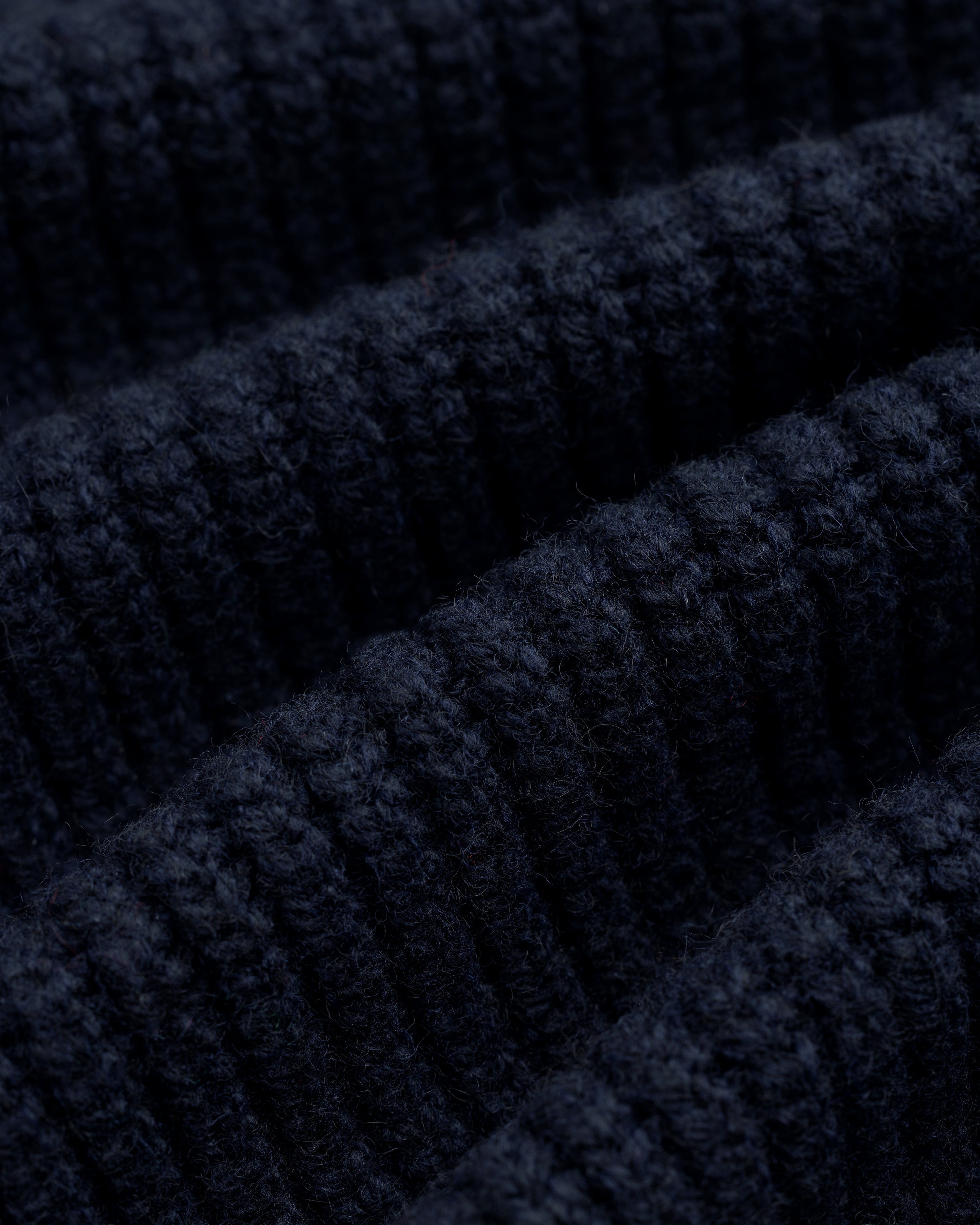 Close-up of NY Highlanders Ribbed Wool Crewneck Sweater, showing textured dark blue knit and soft wool fibers.