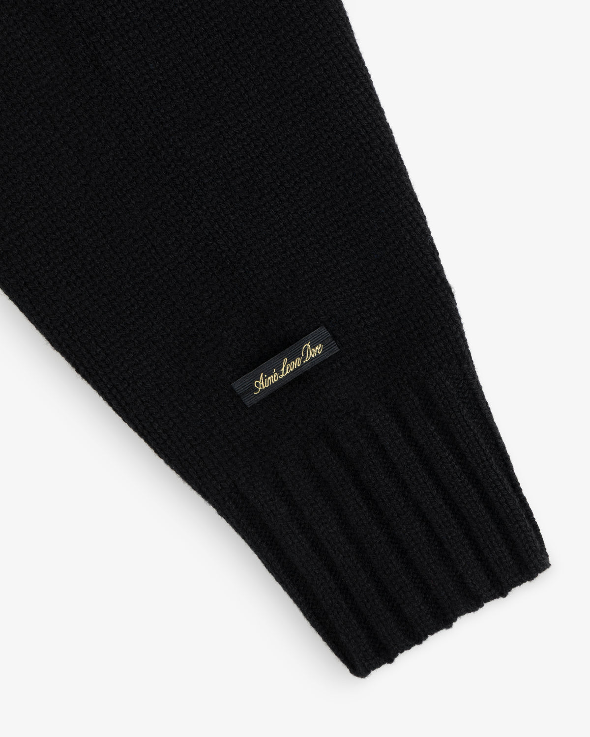 Black Cashmere Crewneck Sweater with a ribbed cuff and a small black label featuring gold embroidery.