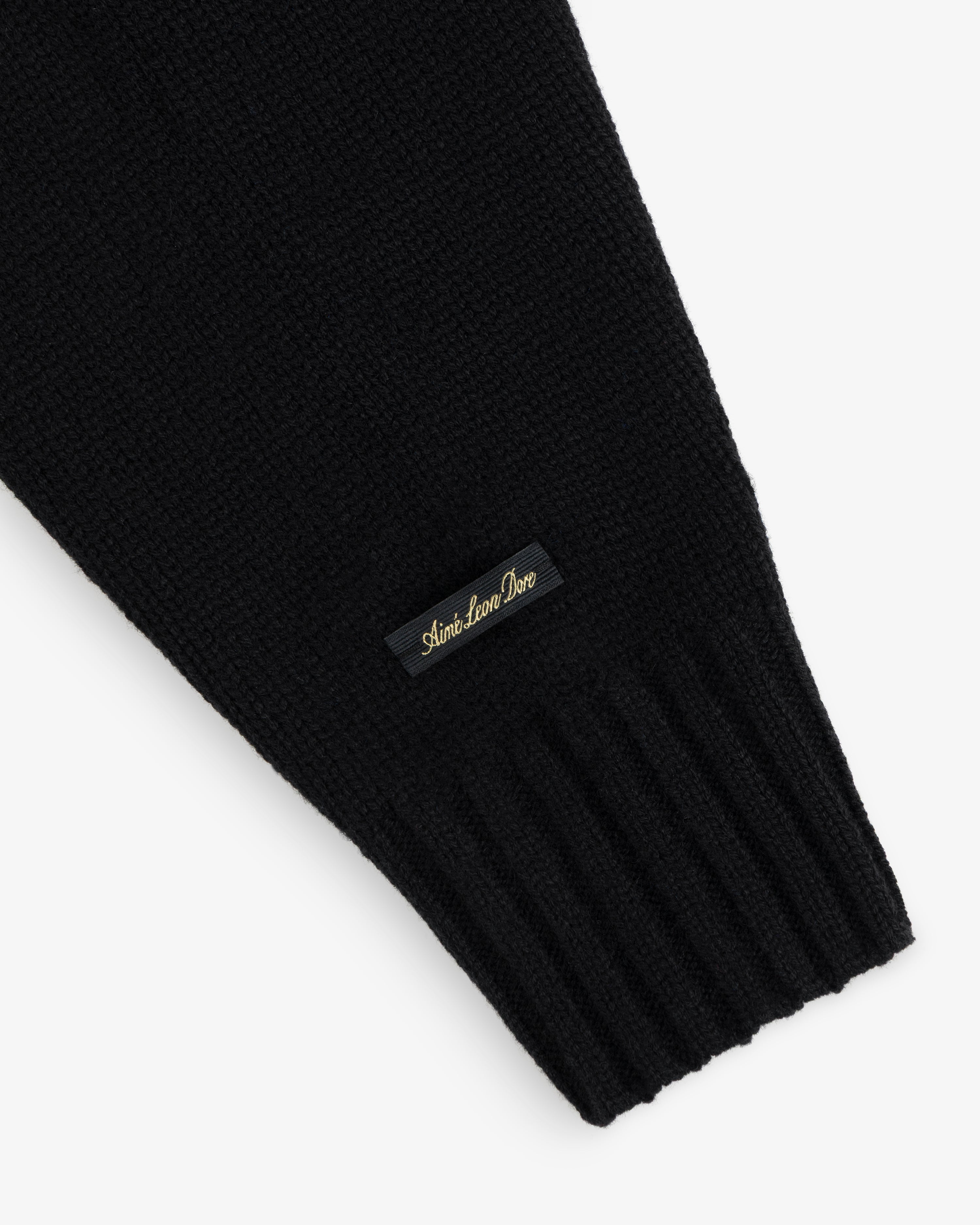 Black Cashmere Crewneck Sweater with a ribbed cuff and a small black label featuring gold embroidery.