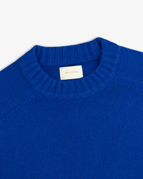 Close-up of a royal blue Cashmere Crewneck Sweater with a ribbed collar and an interior brand label.