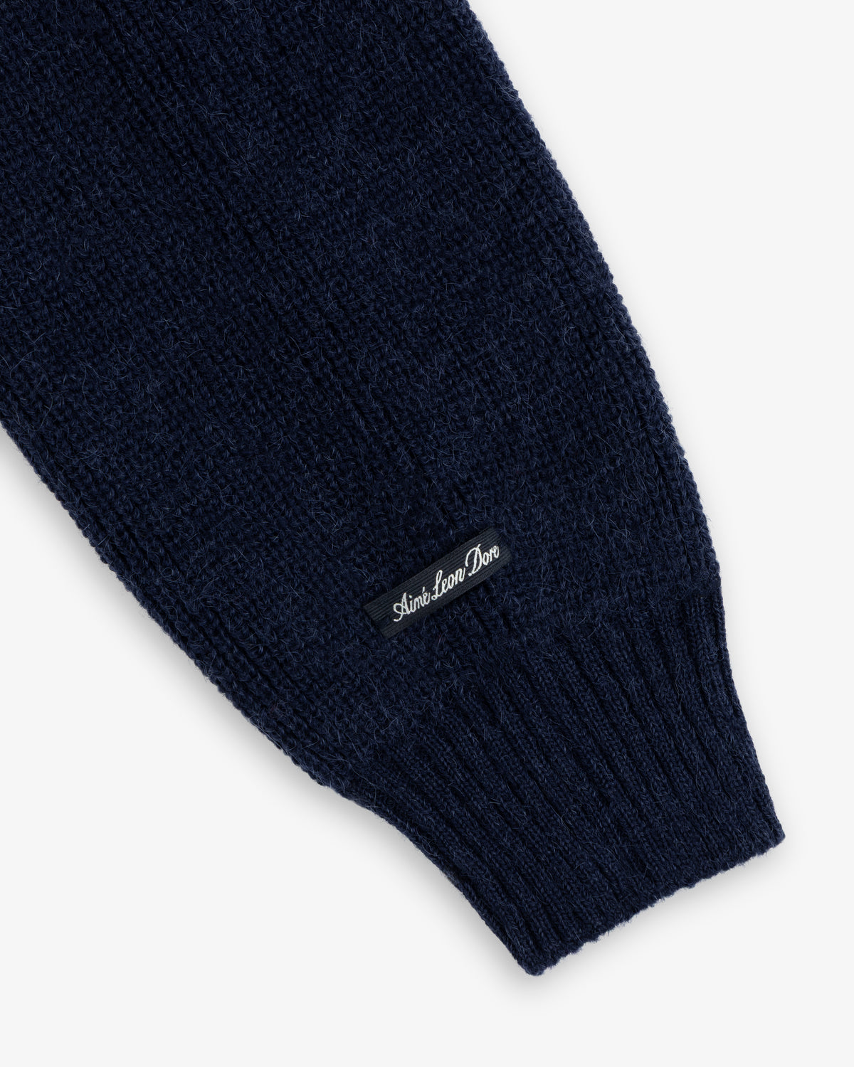 Navy blue Twisted Rib Cardigan sleeve with a ribbed cuff and a small branded tag.