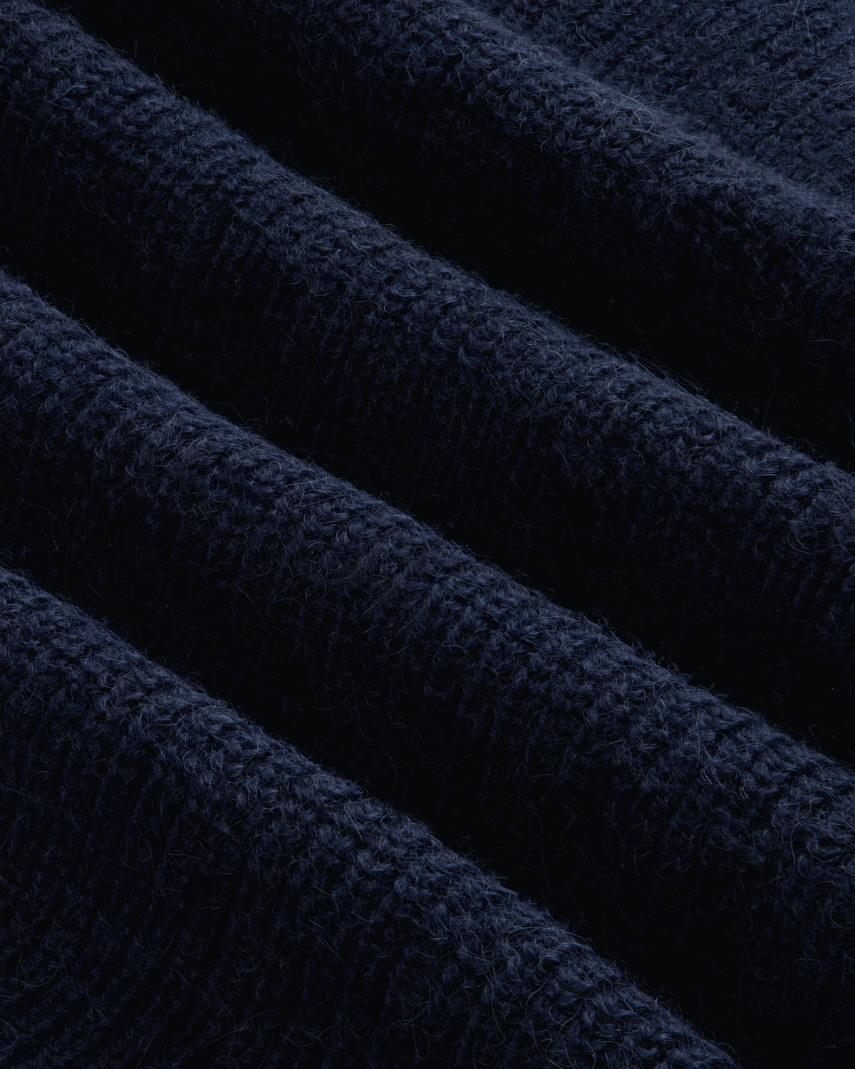 Close-up of the navy blue Twisted Rib Cardigan featuring a visible vertical ribbed knit texture.