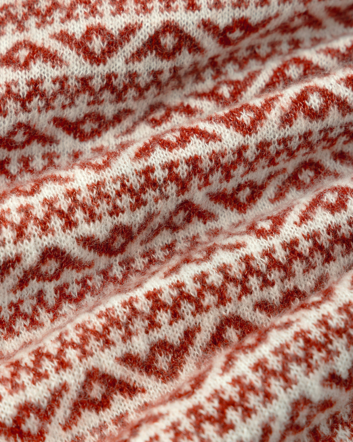 Close-up of the Wool Cashmere Jacquard Cardigan featuring a red and white geometric diamond knit pattern.