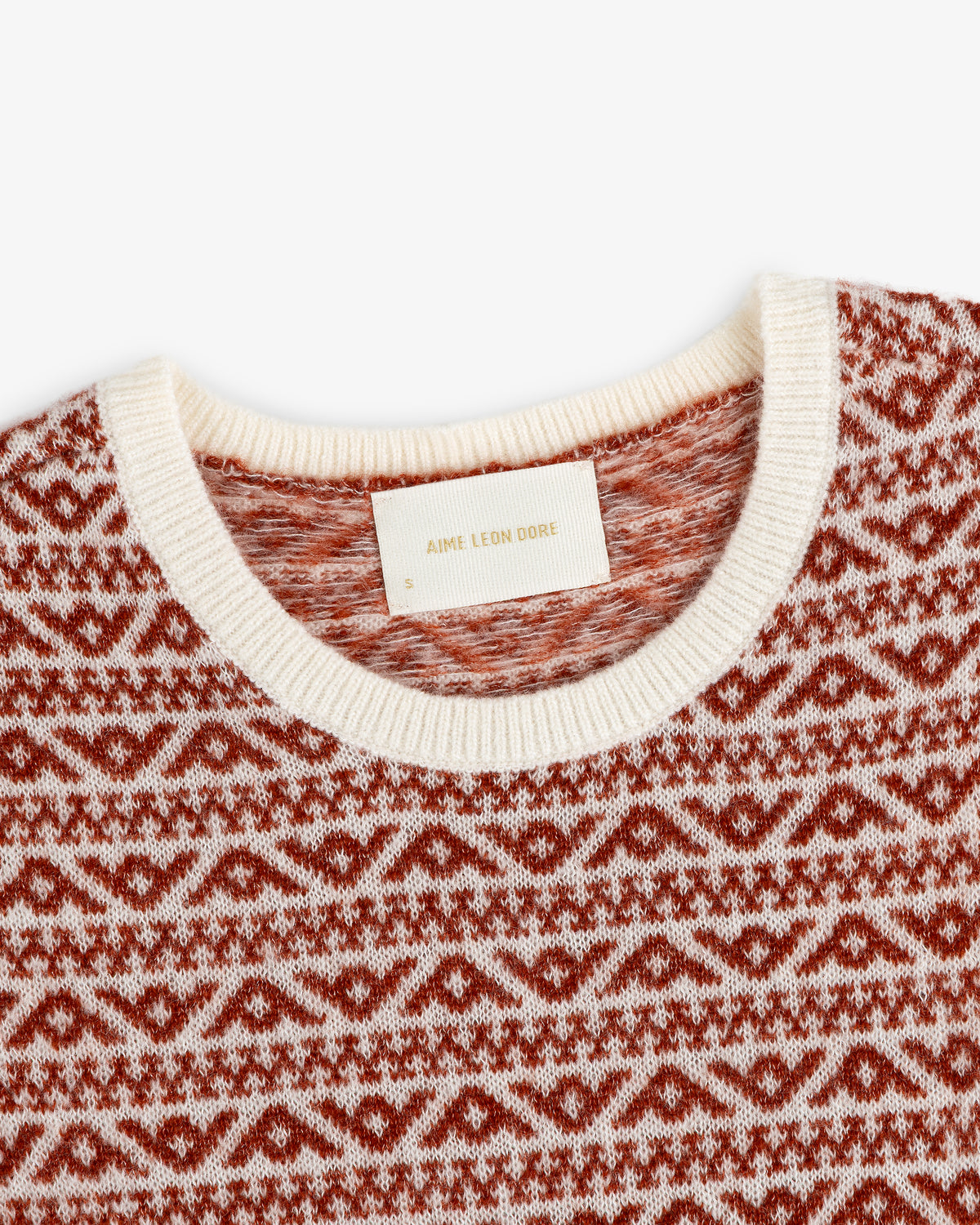 Close-up of a Wool Cashmere Jacquard Shell with a brown and white knit pattern, cream crew neckline, and brand label.