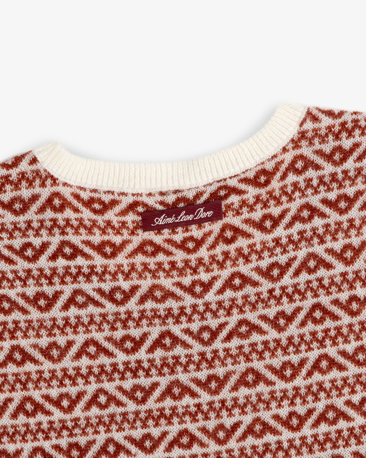 Wool Cashmere Jacquard Shell sleeveless sweater with a cream ribbed neckline and rust-colored geometric pattern.