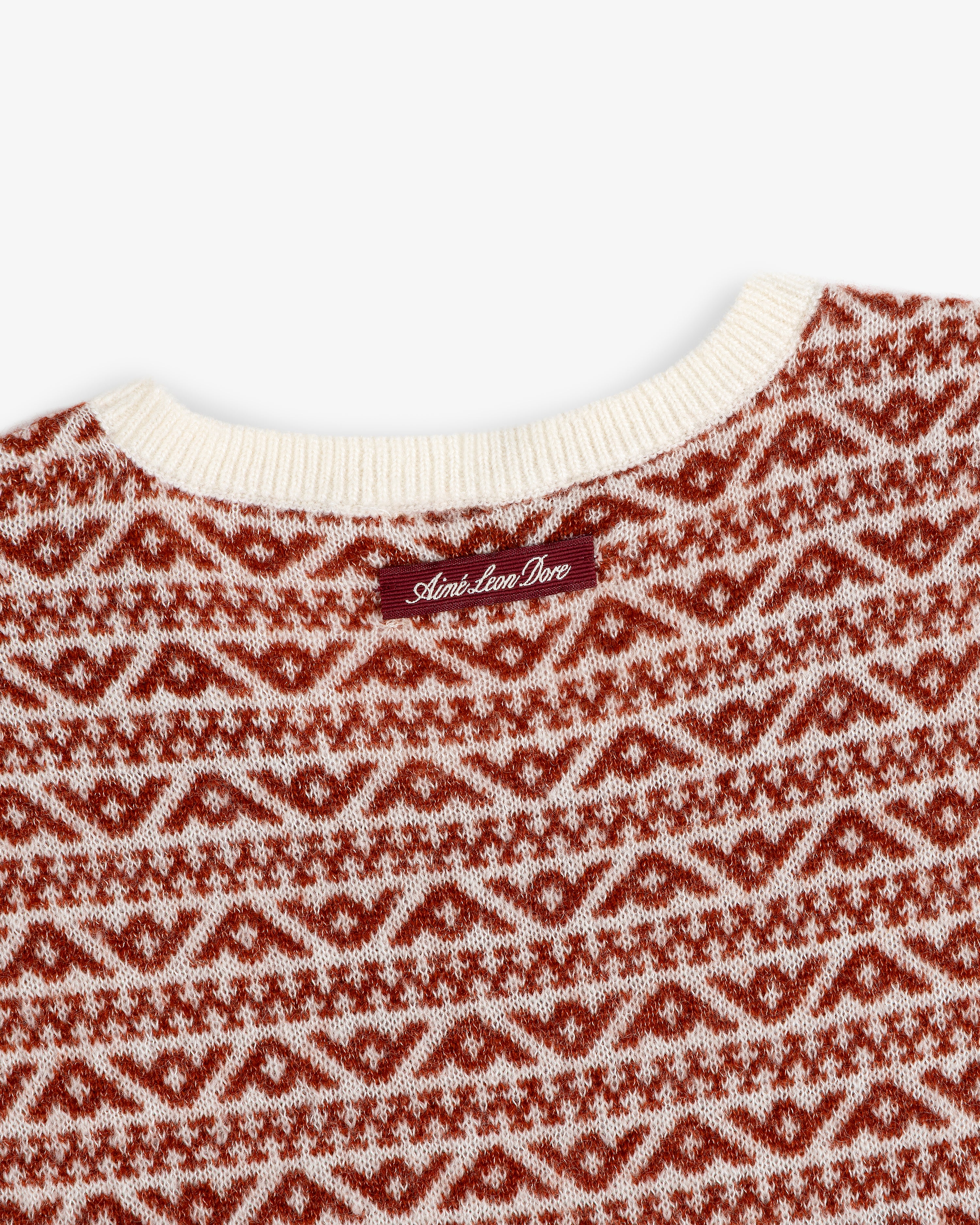 Wool Cashmere Jacquard Shell sleeveless sweater with a cream ribbed neckline and rust-colored geometric pattern.
