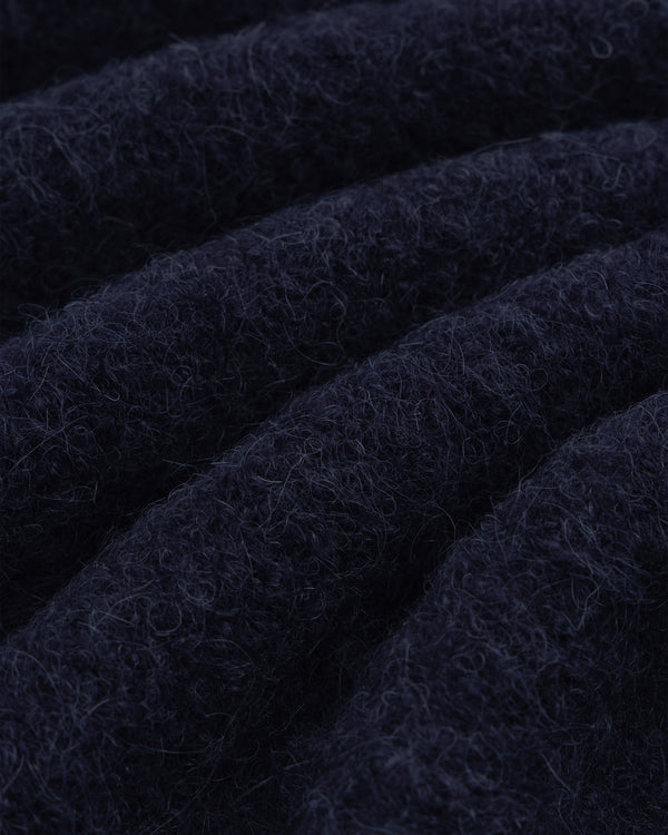 Close-up of dark navy blue alpaca wool from our Quarter Zip Sweater, showing soft texture and wavy ridges.