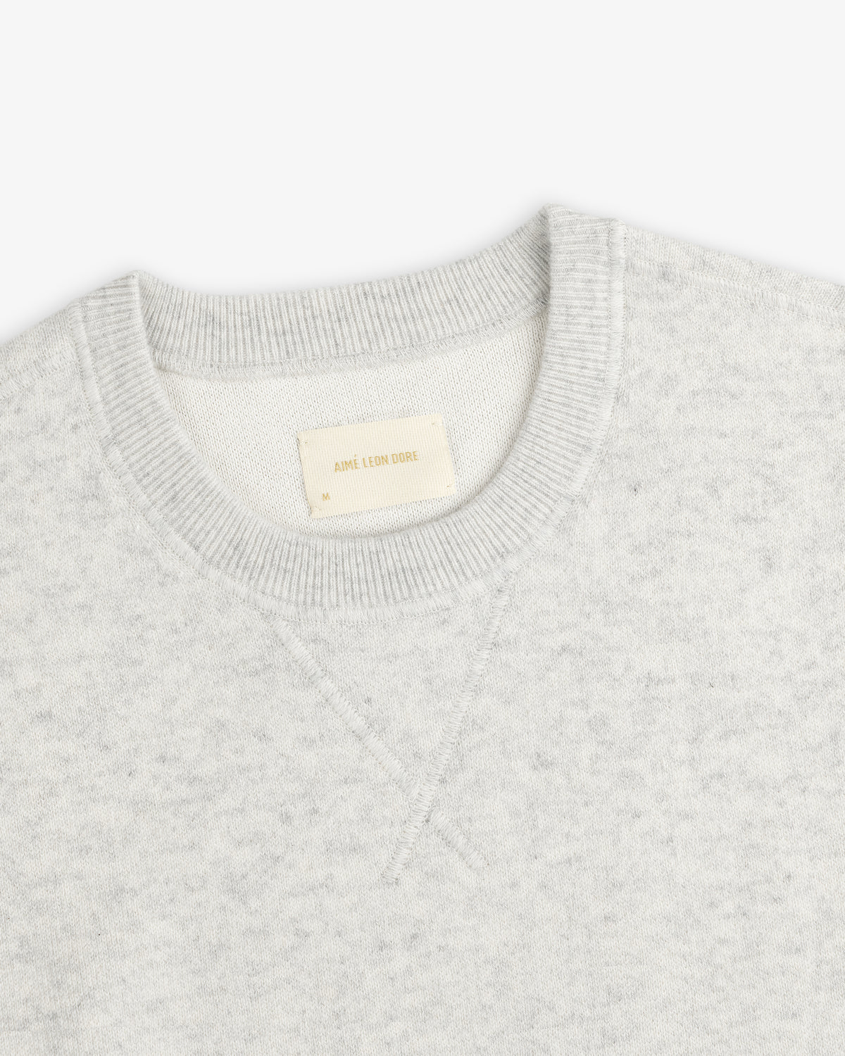 Light gray Pavilion Cashmere Crewneck Sweatshirt with ribbed collar and inside Aime Leon Dore tag.