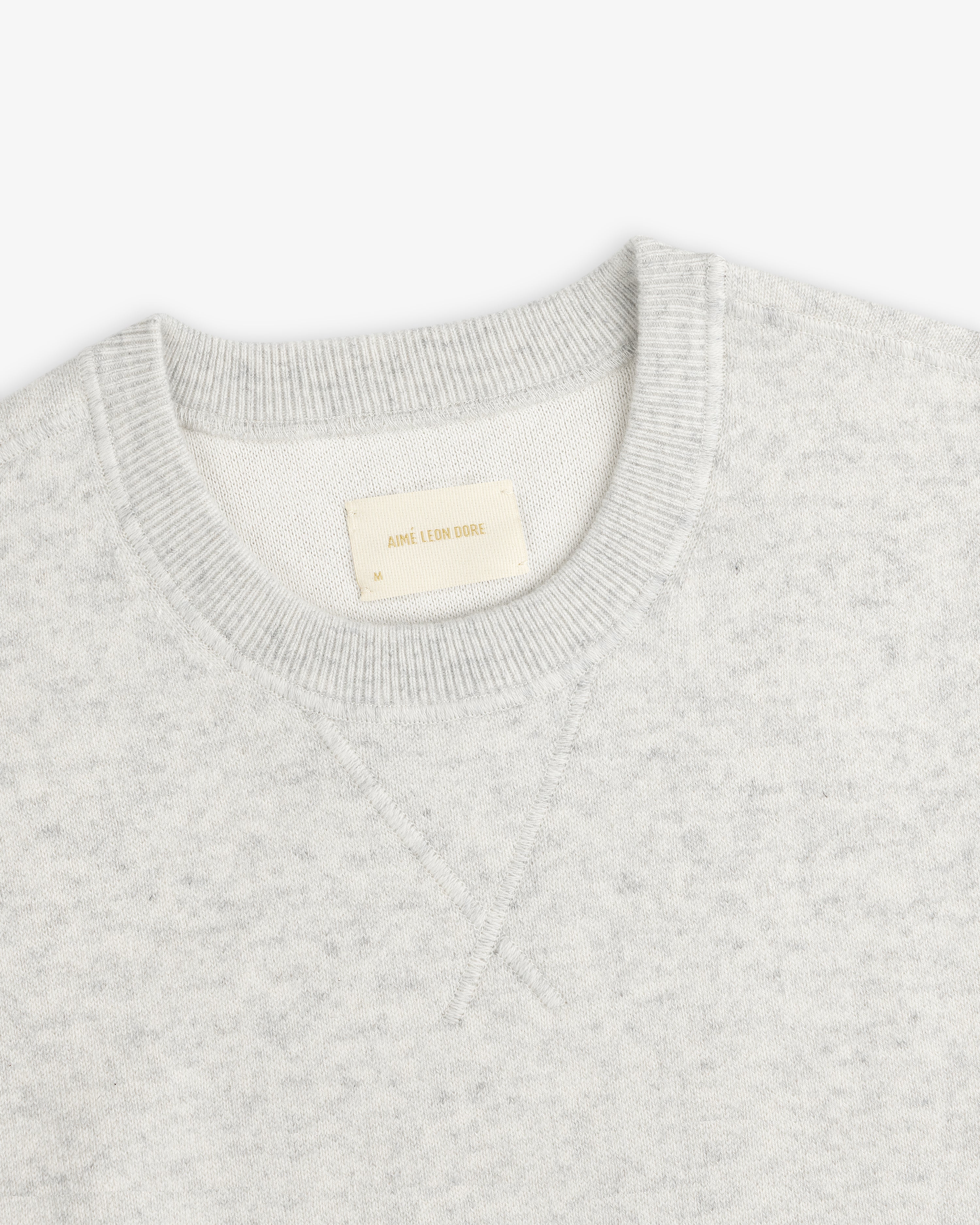 Light gray Pavilion Cashmere Crewneck Sweatshirt with ribbed collar and inside Aime Leon Dore tag.