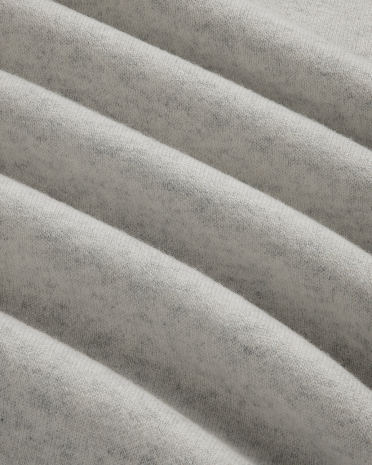 Close-up of light gray Pavilion Cashmere Crewneck Sweatshirt with ribbed, soft fabric and subtle, fuzzy texture.