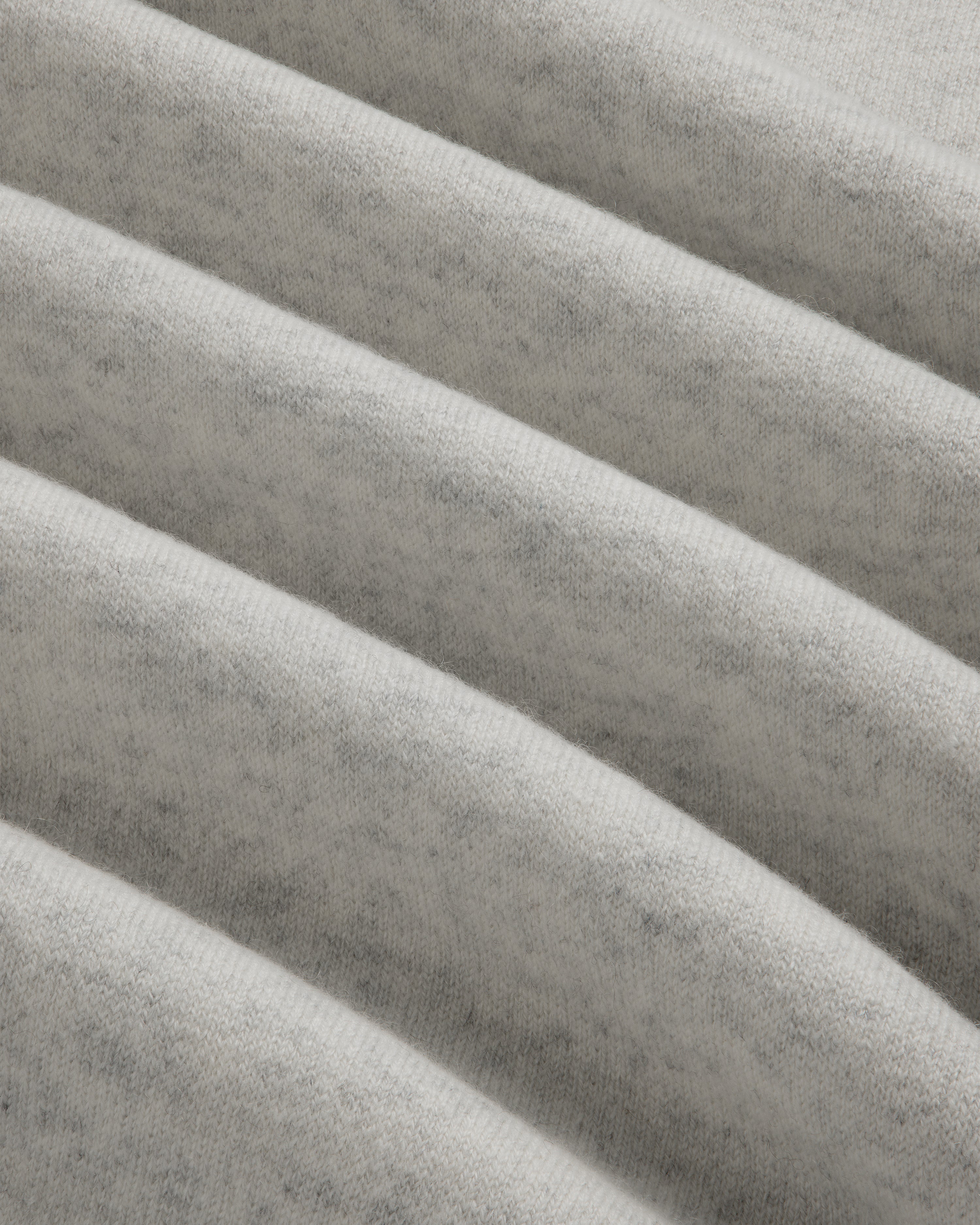 Close-up of light gray Pavilion Cashmere Crewneck Sweatshirt with ribbed, soft fabric and subtle, fuzzy texture.