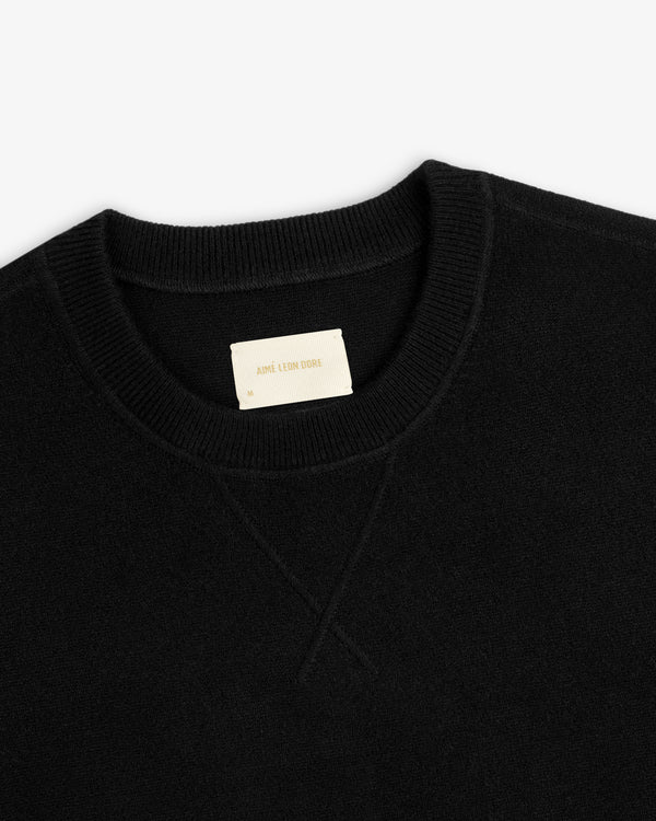 Pavilion Cashmere Crewneck Sweatshirt in black with ribbed collar and beige neck tag featuring text.