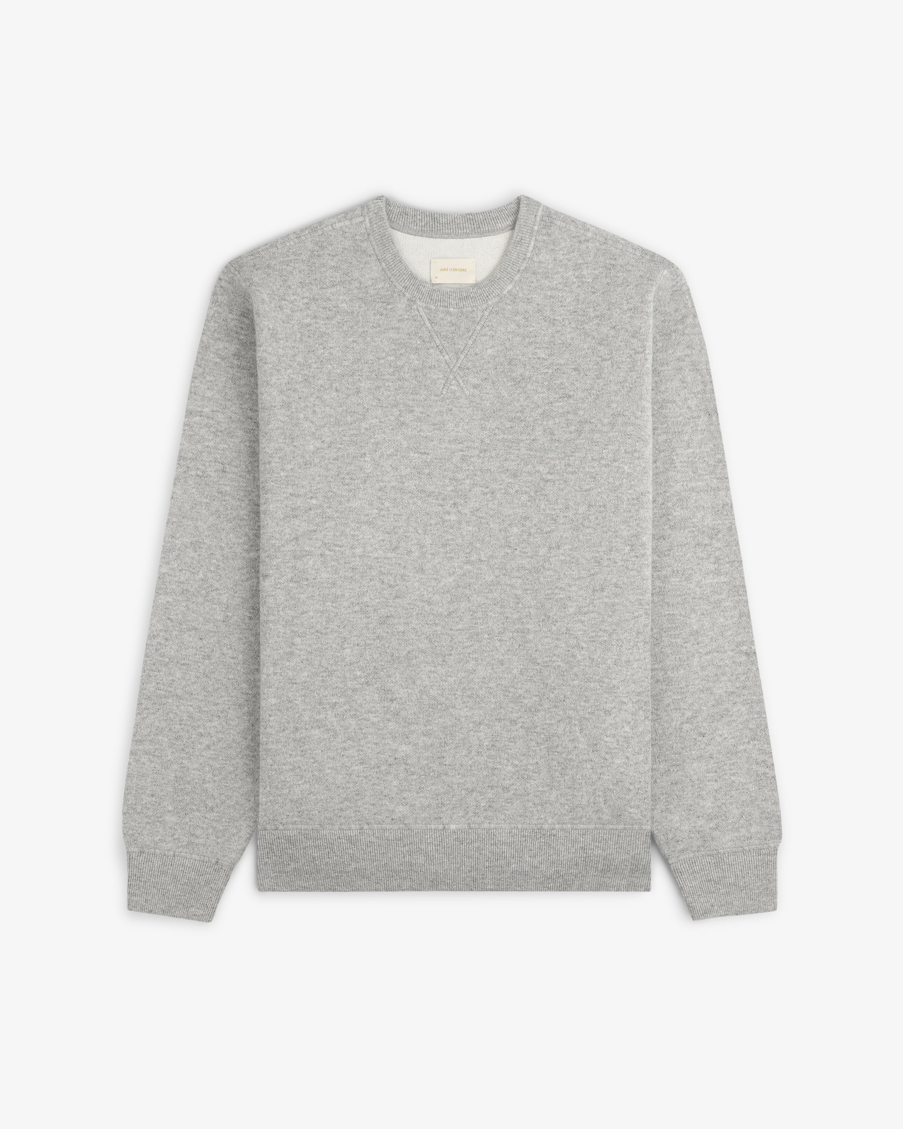 Pavilion Cashmere Crewneck Sweatshirt in light gray, laid flat on white with ribbed cuffs and waistband.