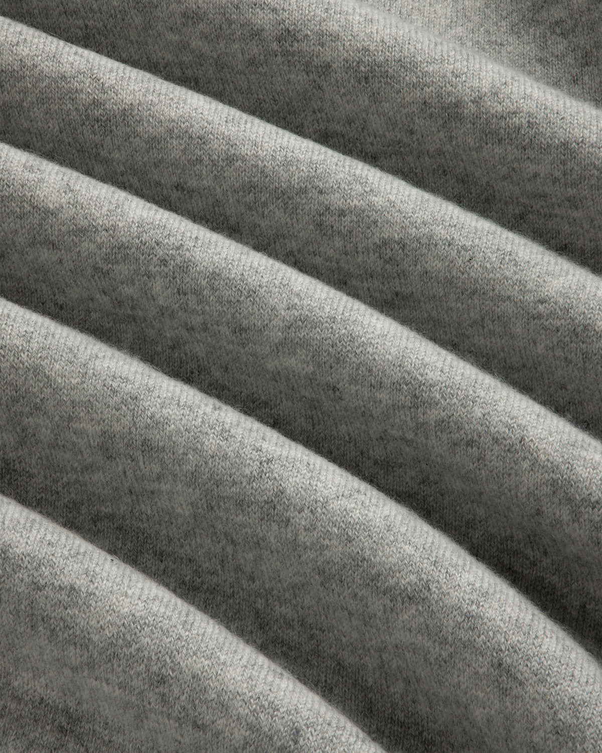 Close-up of Pavilion Cashmere Crewneck Sweatshirt in grey, showing its soft ribbed fabric and horizontal texture.