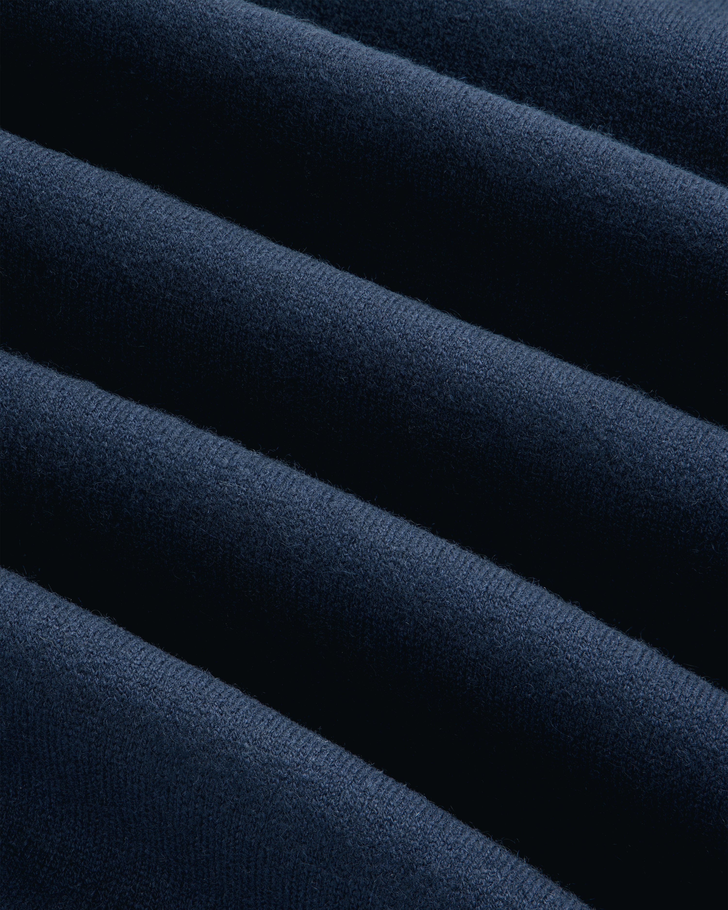 Close-up of soft Pavilion Cashmere Crewneck Sweatshirt in dark blue, with smooth, diagonal, wavy folds.