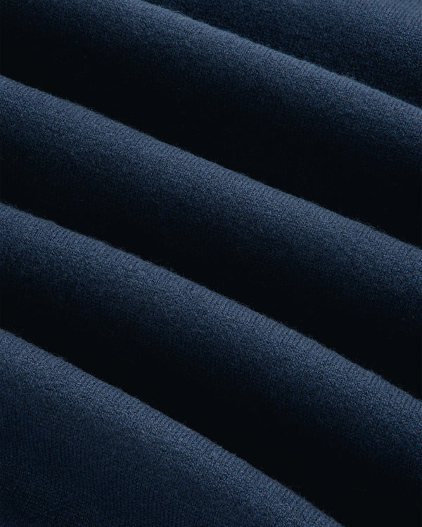 Close-up of soft Pavilion Cashmere Crewneck Sweatshirt in dark blue, with smooth, diagonal, wavy folds.