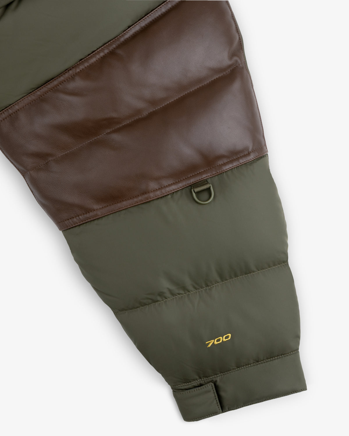 Olive green ALD/North Face Baltoro Jacket sleeve with brown leather, black clip, and yellow 700 embroidery.