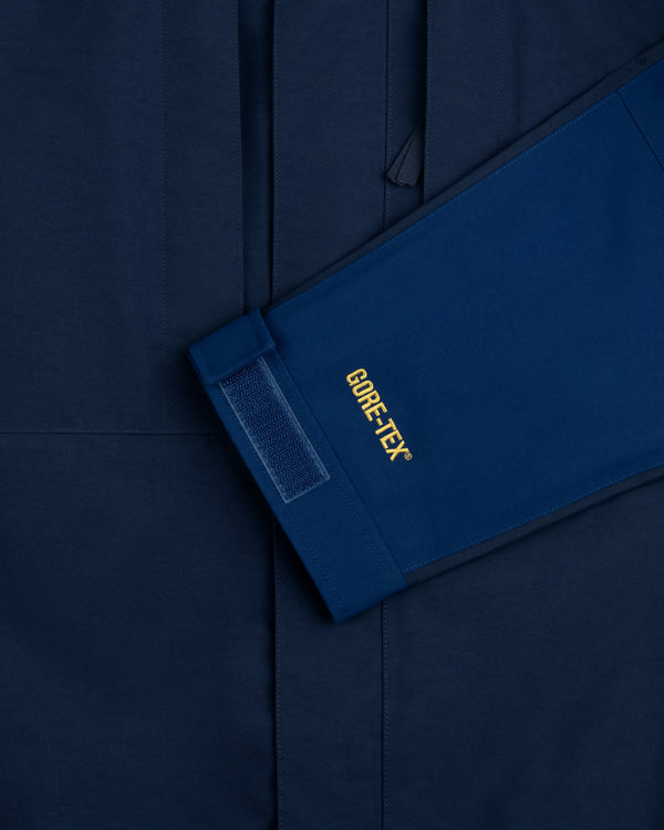 A blue ALD/The North Face GORE-TEX 2000 Mountain Jacket sleeve with velcro rests on a matching blue background.