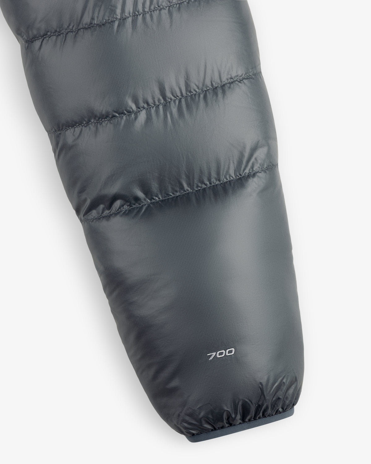 Close-up of an ALD/The North Face Reversible Pertex® Nuptse Jacket sleeve with “700” near the cuff on gray fabric.