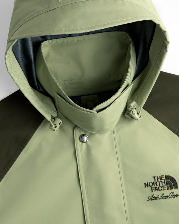 Light green ALD / The North Face GORE-TEX Trench Coat with chest logos, shown in close-up.