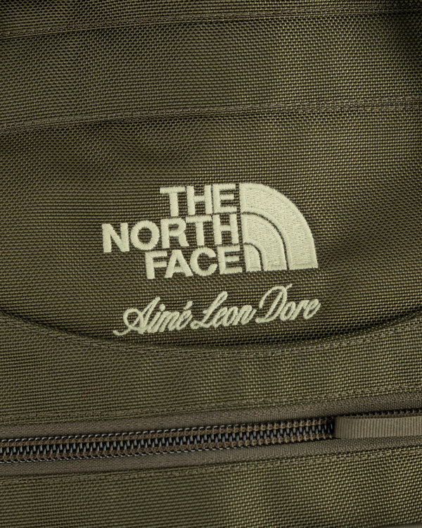 Close-up of olive green ALD / The North Face Ballistic Tech Vest with both brands’ logos above a zipper.