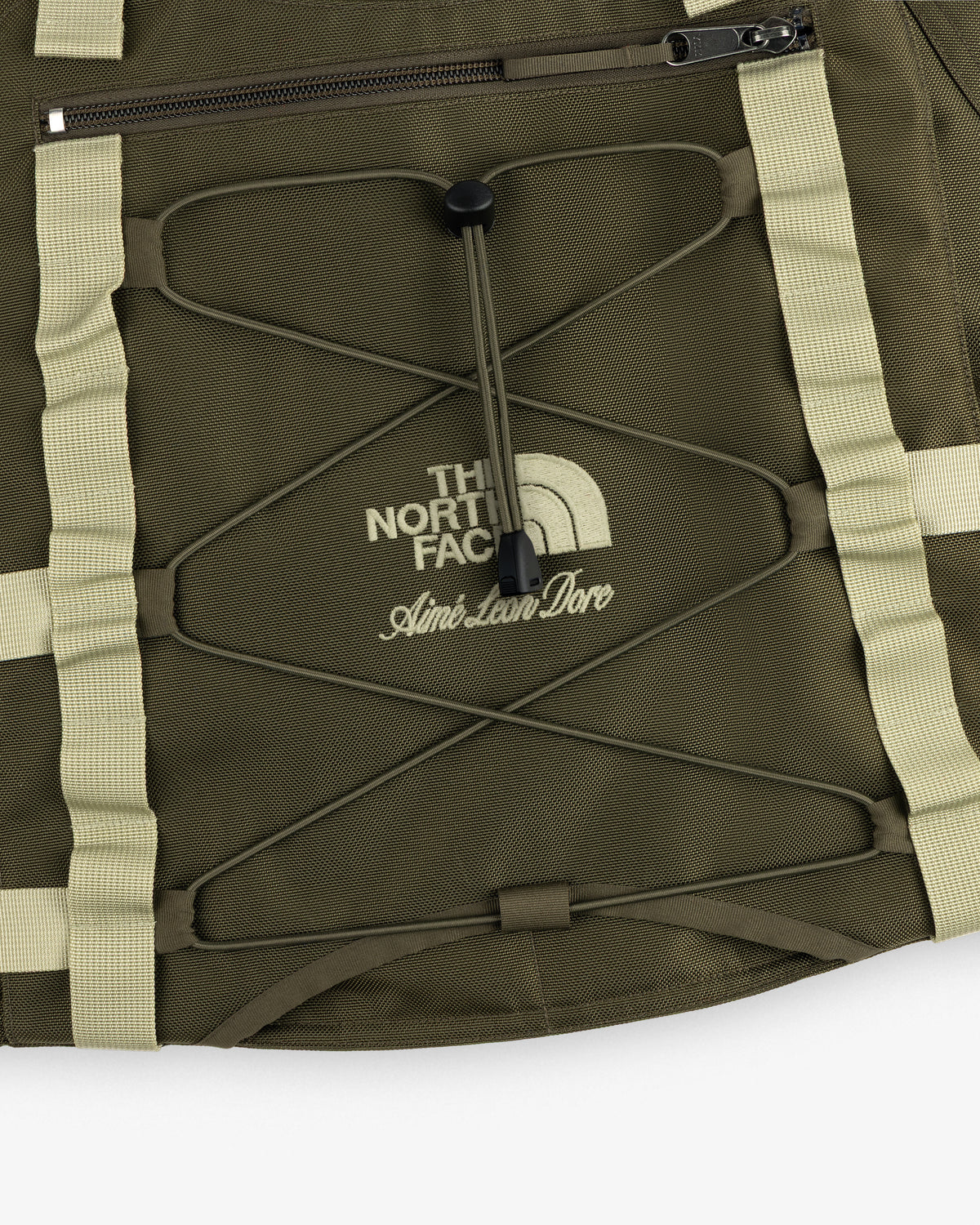 Olive green ALD / The North Face Ballistic Tech Vest with tan straps, zipper, and printed logos.