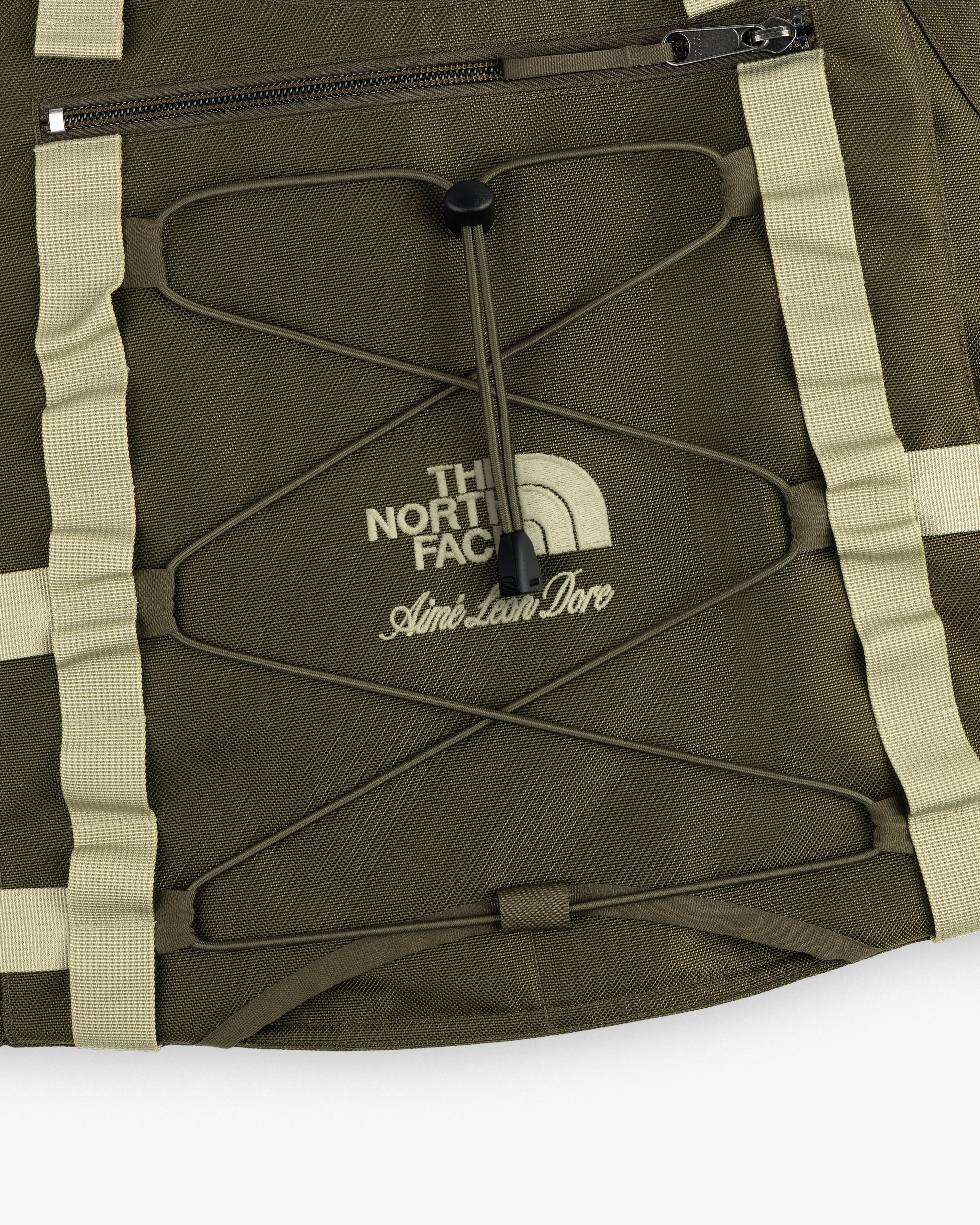 Olive green ALD / The North Face Ballistic Tech Vest with tan straps, zipper, and printed logos.