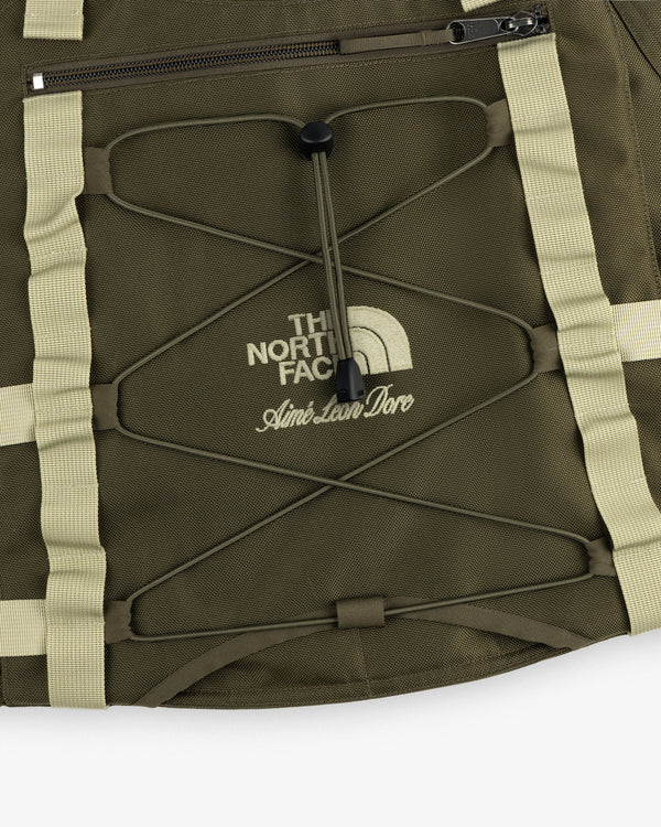 Olive green ALD / The North Face Ballistic Tech Vest with tan straps, zipper, and printed logos.