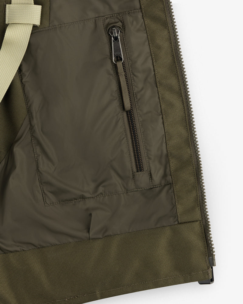 Close-up of the ALD / The North Face Ballistic Tech Vest pocket with vertical zipper and beige strap on the left.