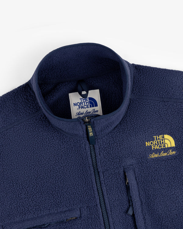 Close-up of a navy ALD / The North Face ’95 Denali Half-Zip Fleece Pullover with yellow logo and chest pocket.