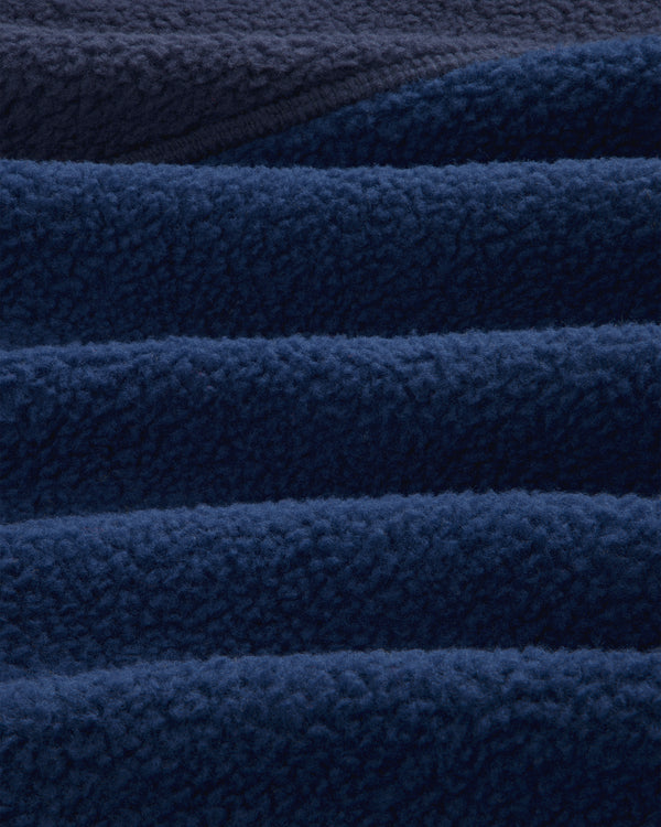 Close-up of ALD/The North Face ’95 Denali Half-Zip Fleece Pullover in deep blue, showing soft, wave-like folds.