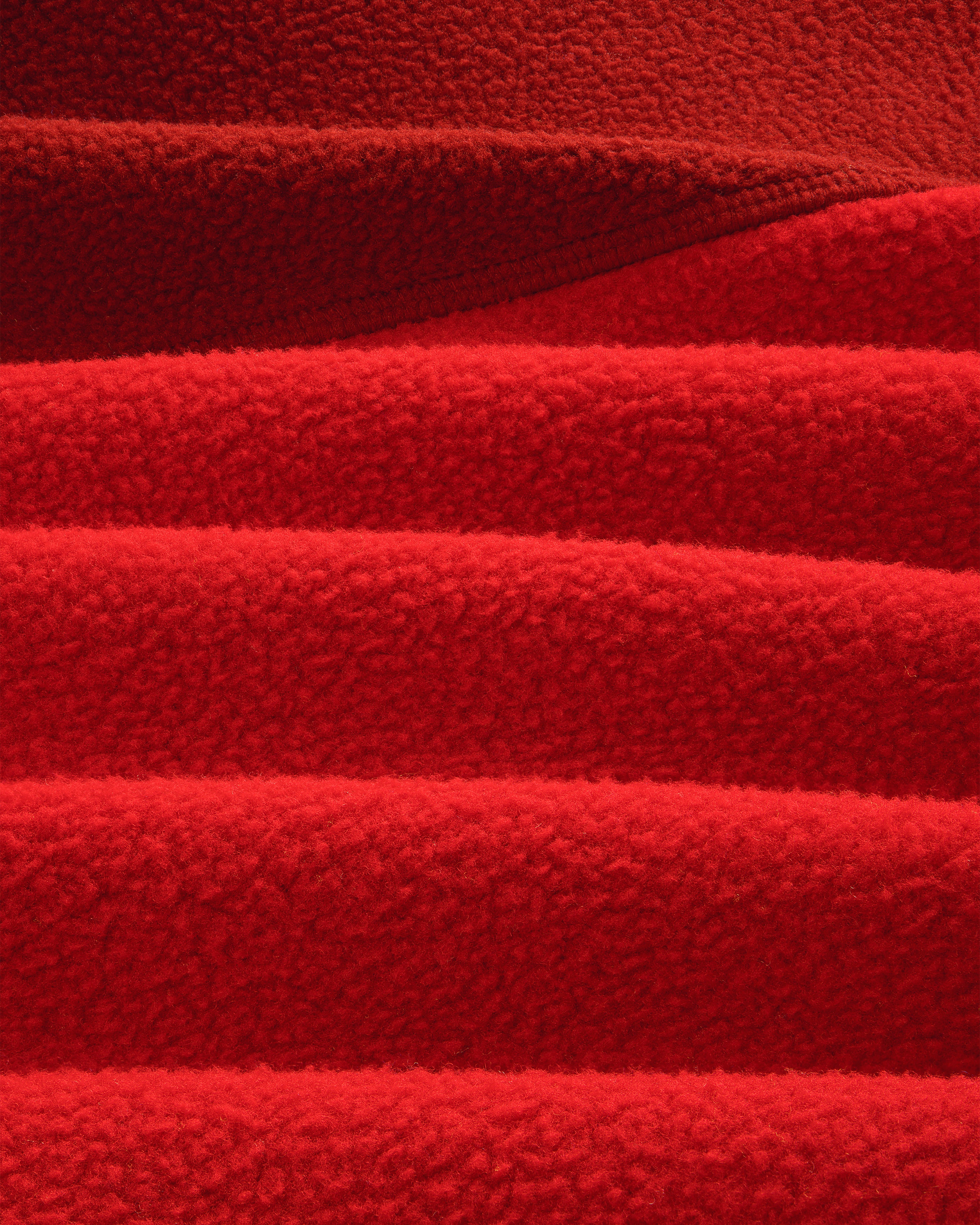 Detail of ALD / The North Face ’95 Denali Half-Zip Fleece Pullover: overlapping, textured red fleece with soft lines.