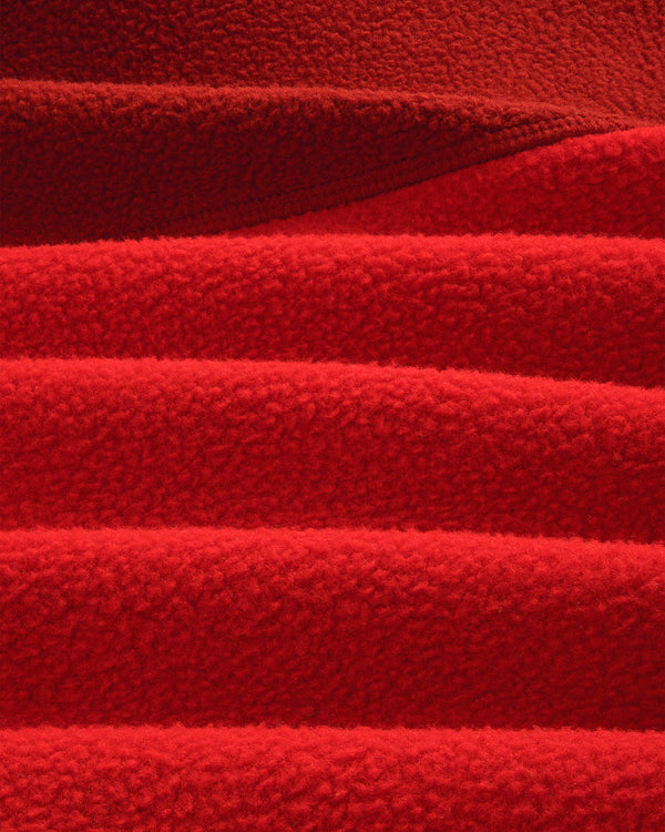 Detail of ALD / The North Face ’95 Denali Half-Zip Fleece Pullover: overlapping, textured red fleece with soft lines.