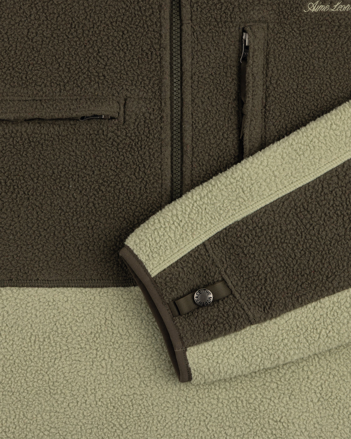 Close-up of ALD / The North Face ’95 Denali Half-Zip Fleece Pullover in olive/light green with zips and snap sleeve detail.