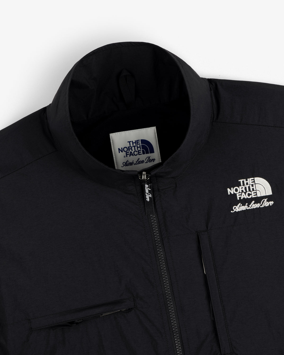Close-up of a black ALD / The North Face Nylon Denali Jacket, featuring logo and zipper details.