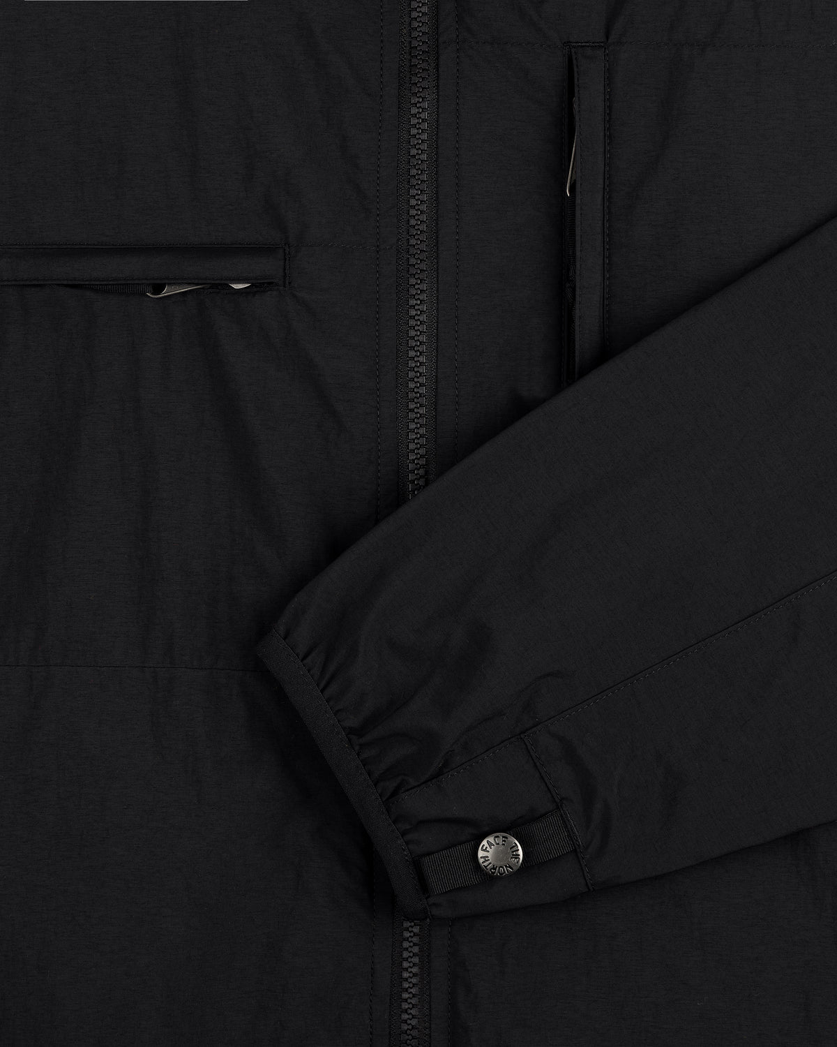 Close-up of ALD / The North Face Nylon Denali Jacket’s black sleeve with snap button cuff and zippered pockets.
