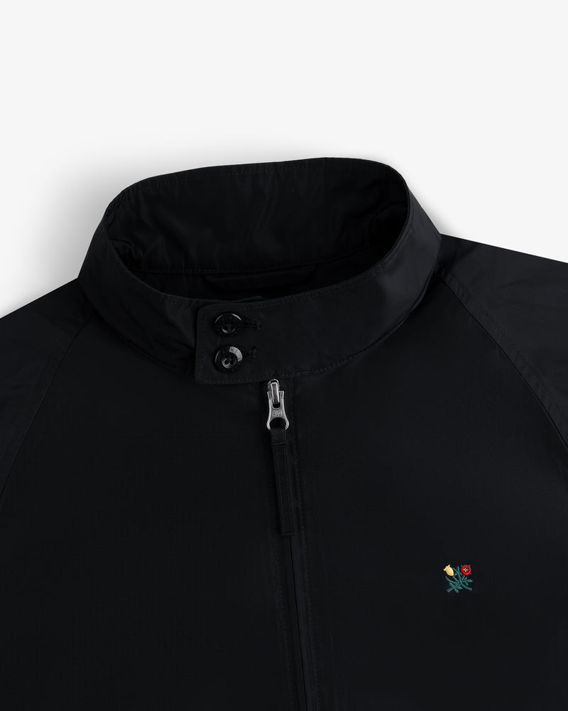 Crest Nylon Windbreaker: black, zip-up, two-collar buttons, small colorful flower embroidered on chest.