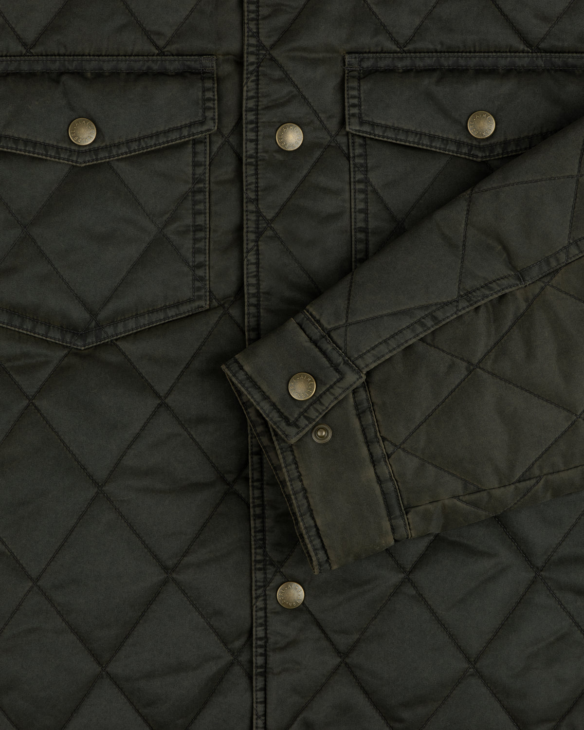 Dark olive quilted Quilted Trucker Jacket with chest pockets, metal buttons, and a buttoned cuff.
