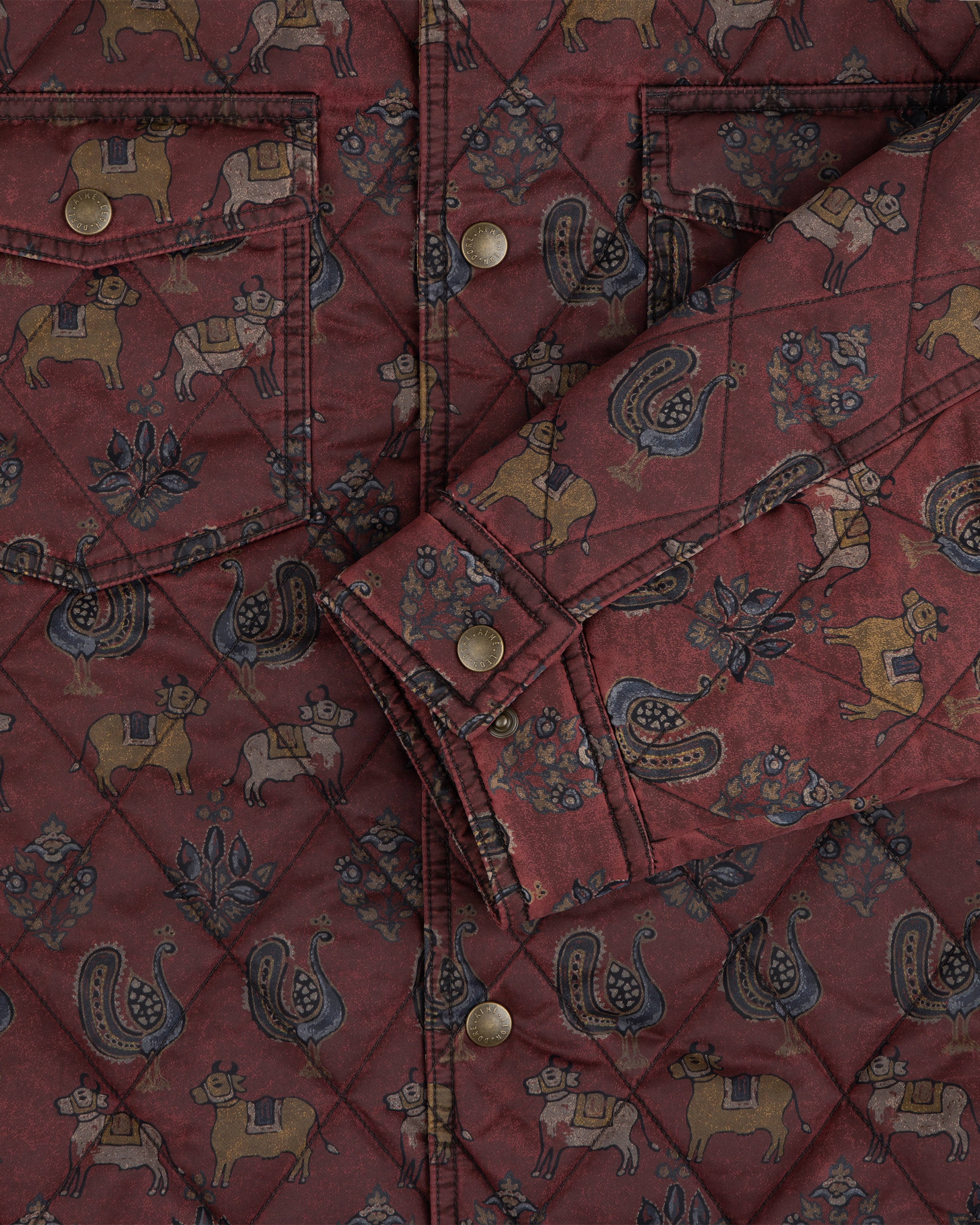 Quilted Trucker Jacket in deep red fabric with folk-style animals, plants, and metal buttons.