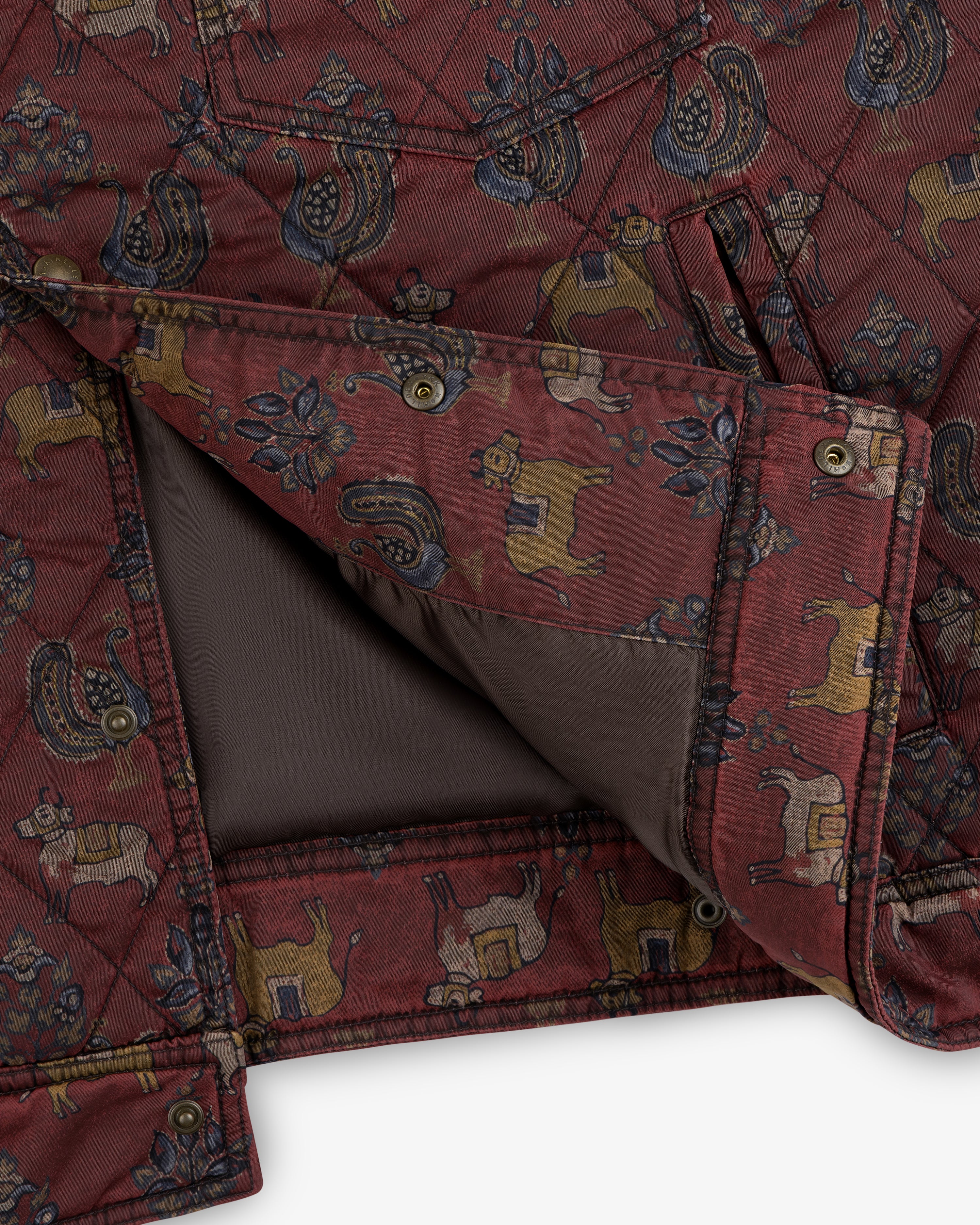 Close-up of a dark red Quilted Trucker Jacket featuring a repeating pattern of stylized roosters and cattle.