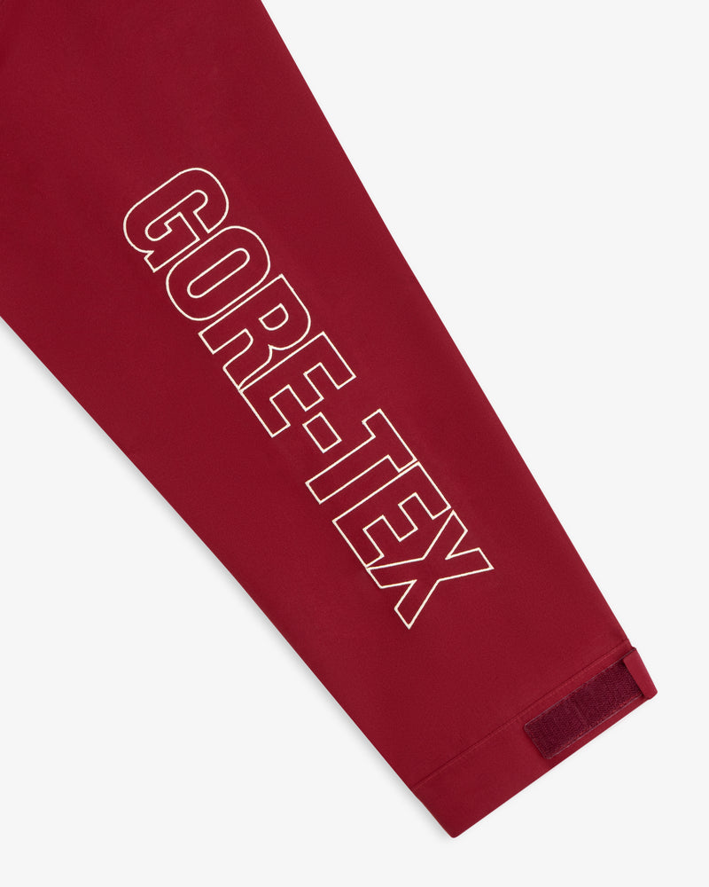 Red sleeve of the GORE-TEX Striped Sailing Jacket with bold white GORE-TEX text and Velcro cuff strap.