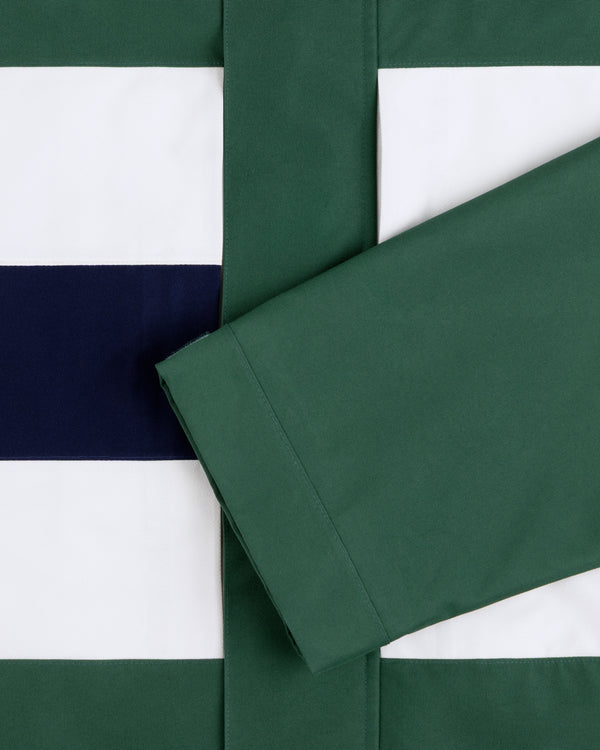 A green sleeve rests on striped white, navy, and green GORE-TEX Striped Sailing Jacket fabric.